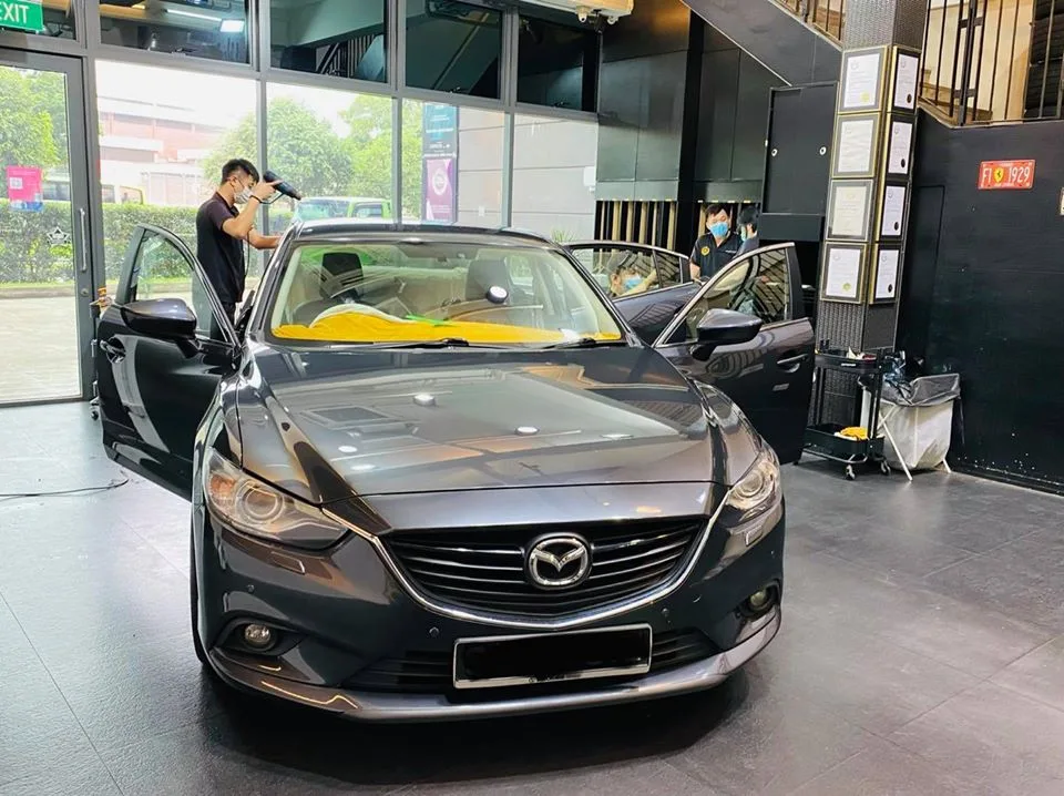 Grey Mazda 6 sedan during tint install with a heat gun at Infratint Singapore