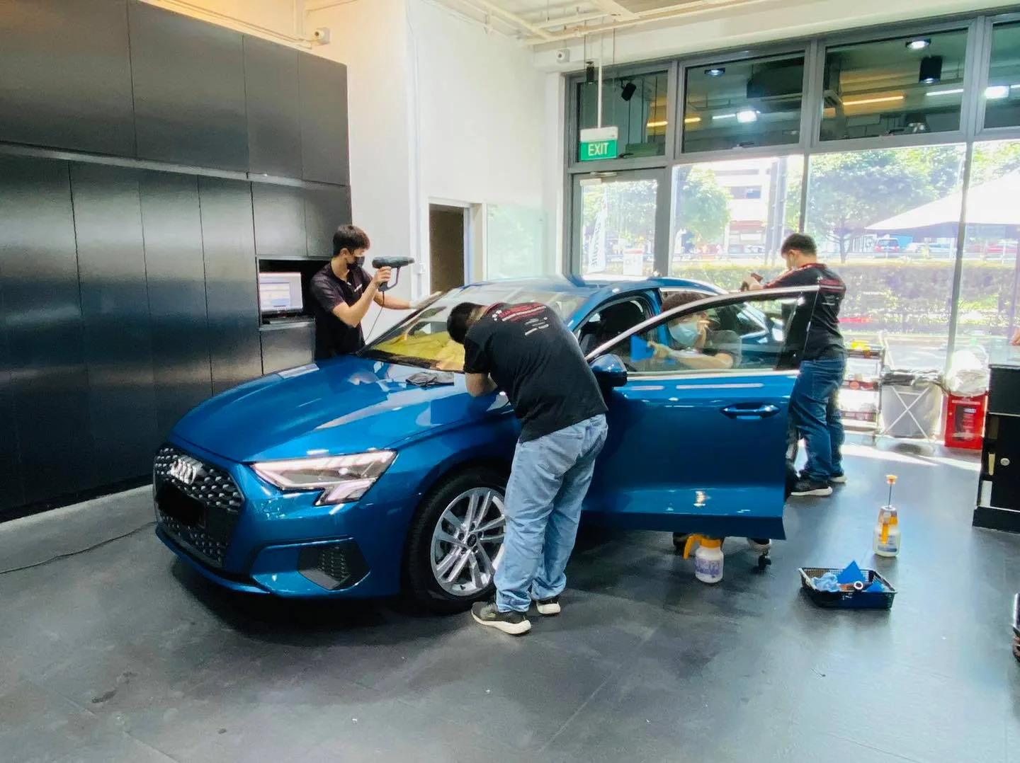 Blue Audi A3 sedan being tinted with a heat gun at Infratint Singapore