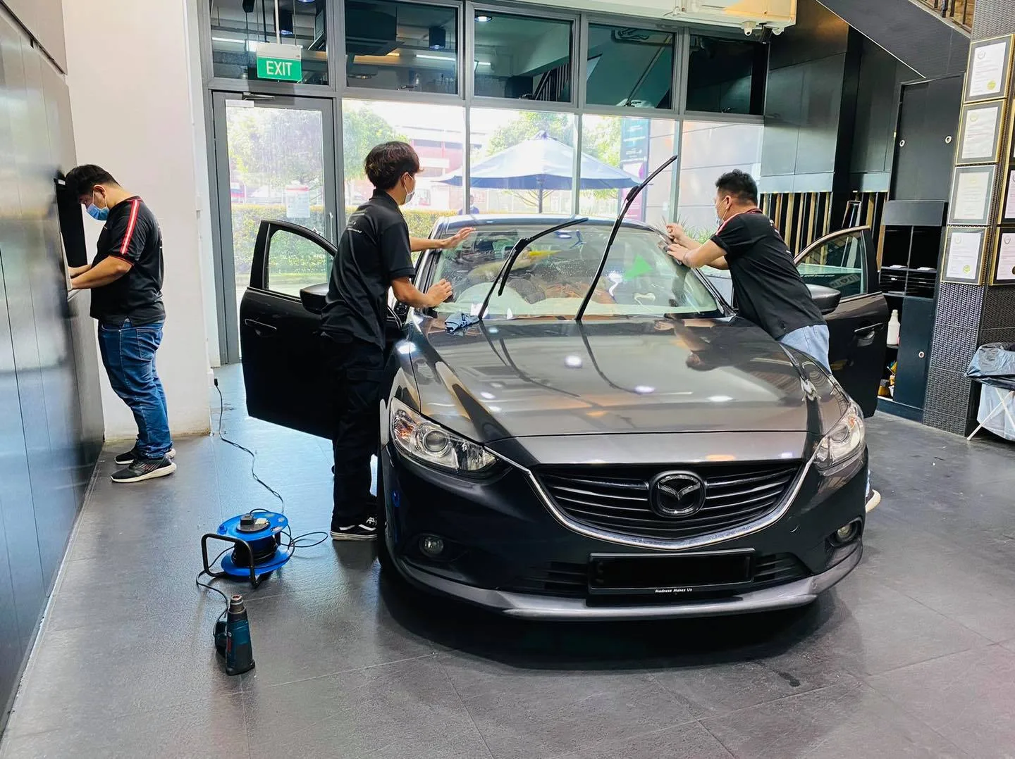 Grey Mazda 6 getting windscreen film fitted by the team at Infratint Singapore