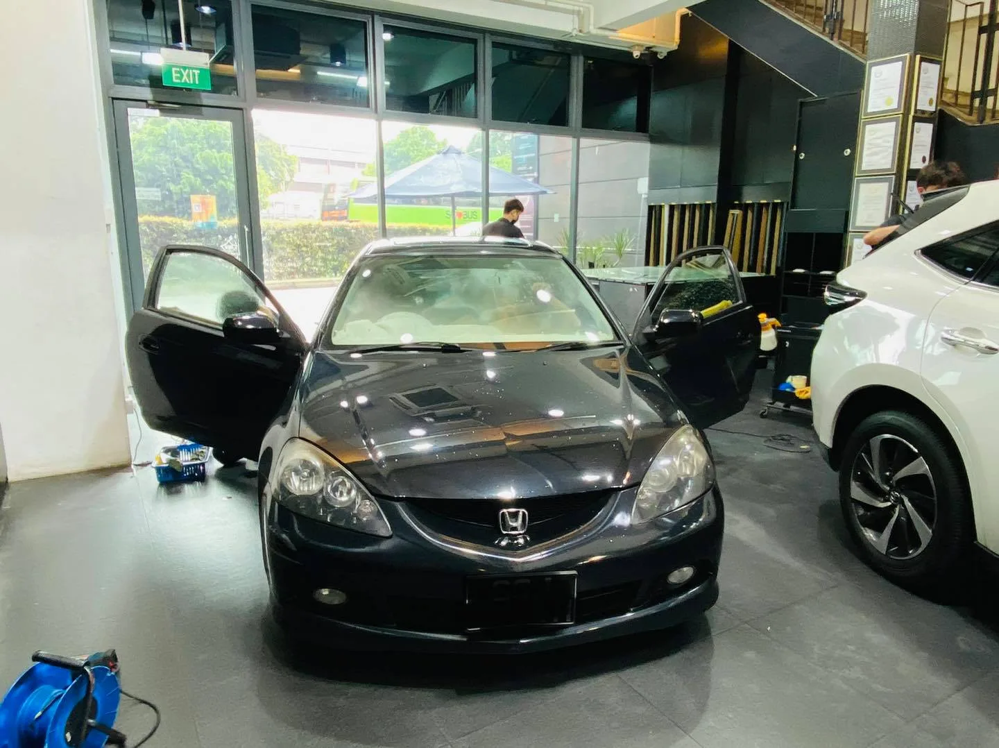 Black Honda coupe with door open during window film install at Infratint Singapore