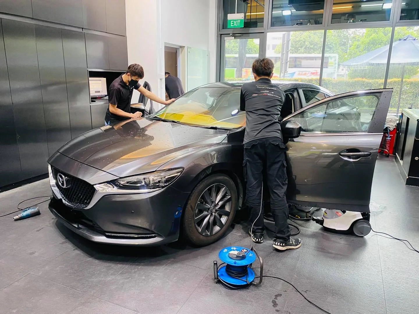 Front three-quarter view of a grey Mazda 6 during window tinting at Infratint Singapore