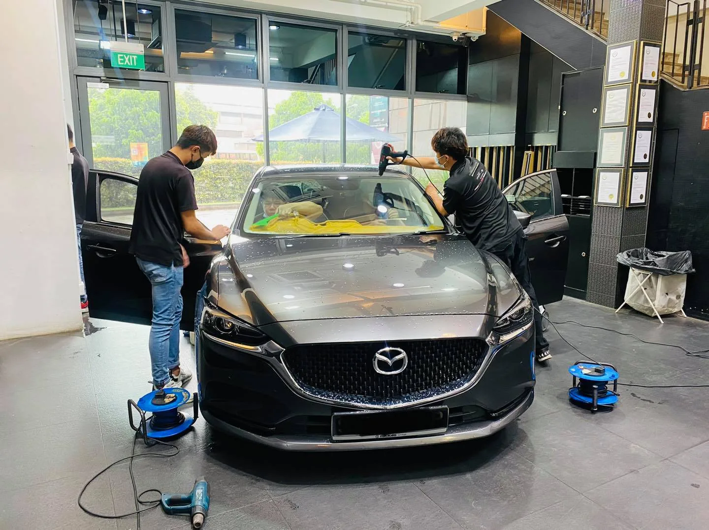 Grey Mazda 6 sedan getting window film fitted by two installers at Infratint Singapore