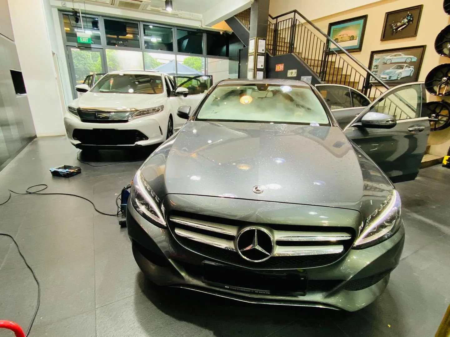 Grey Mercedes-Benz sedan front view at Infratint Singapore with a white Toyota SUV behind