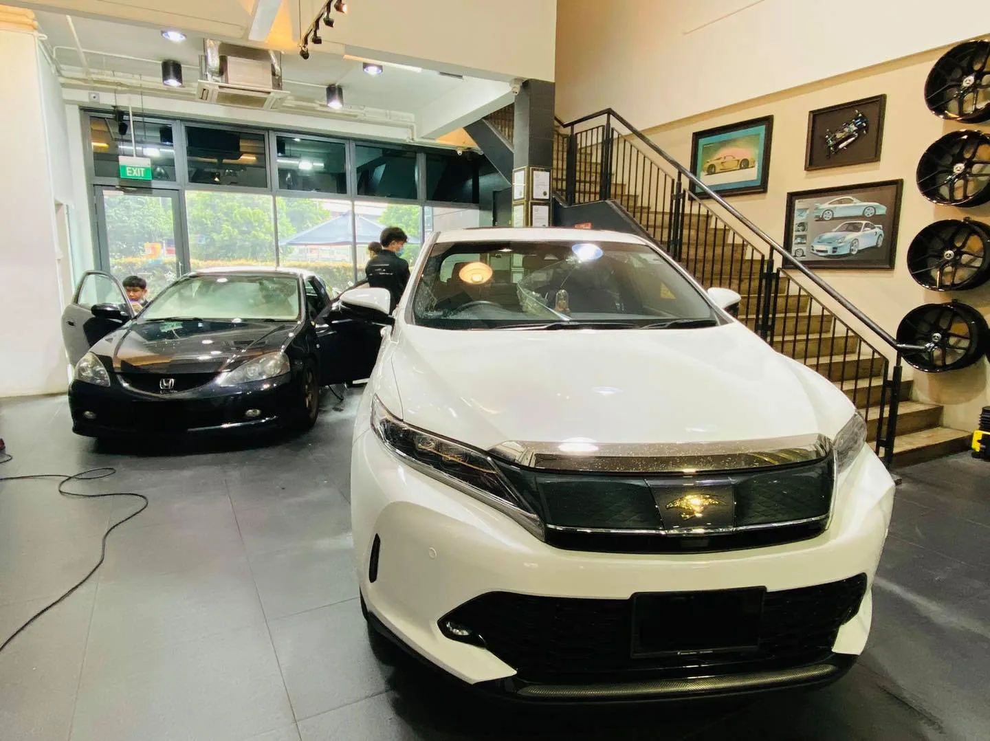 White Toyota SUV and a dark sedan inside the Infratint Singapore showroom