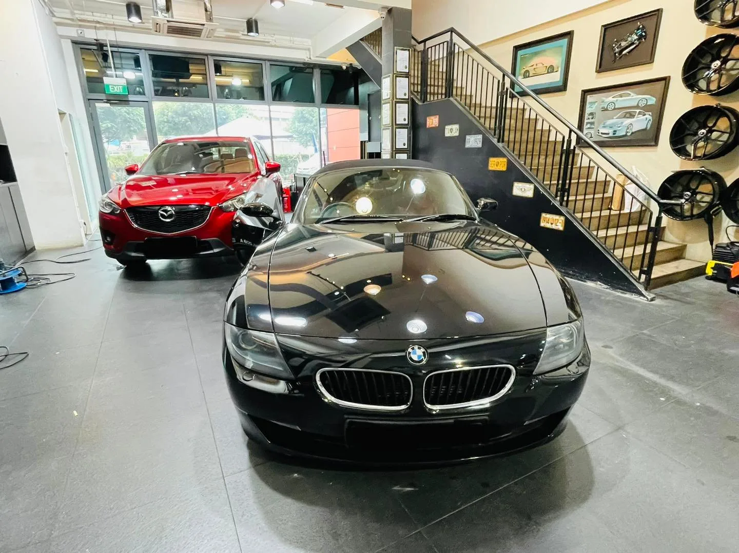 Black BMW Z4 roadster and red Mazda CX-5 inside Infratint Singapore showroom