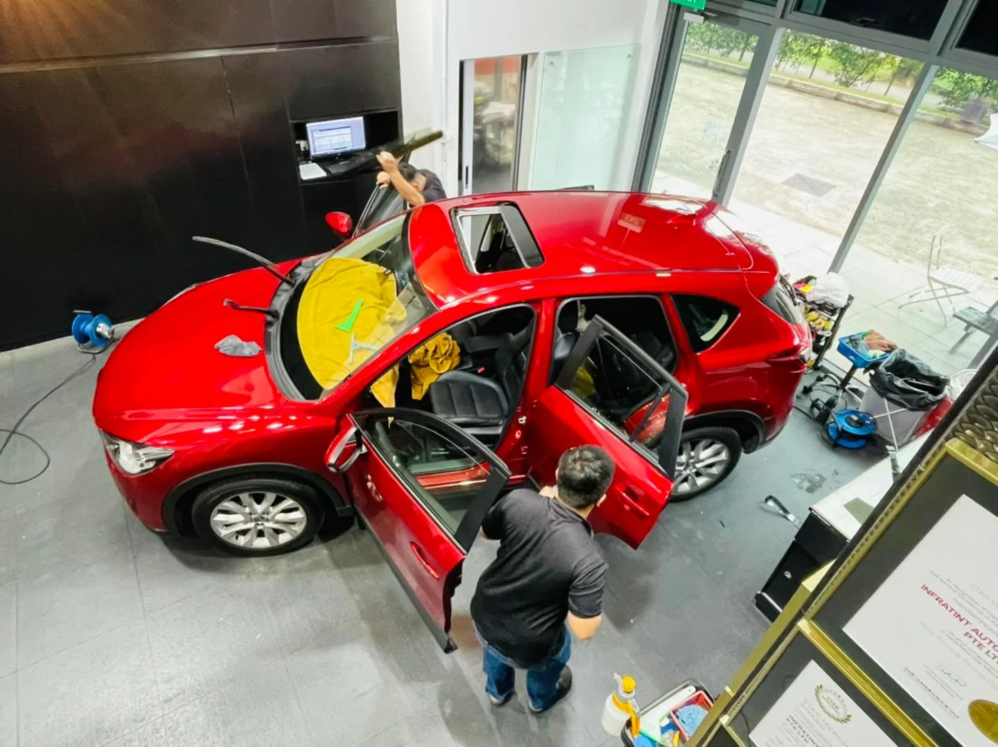 Overhead view of a red Mazda CX-5 during window film installation at Infratint Singapore