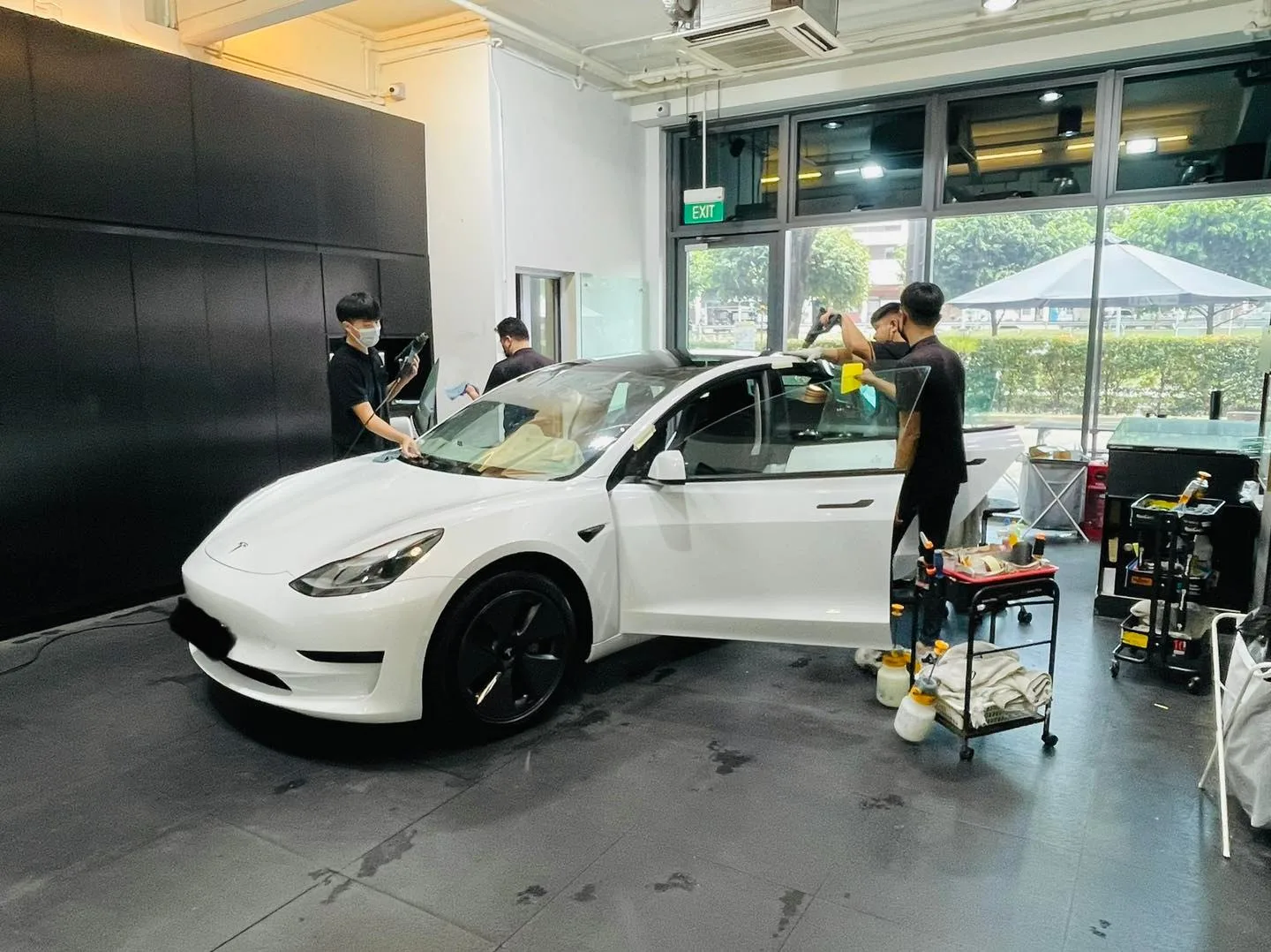 White Tesla Model 3 side view during window tinting at Infratint Singapore