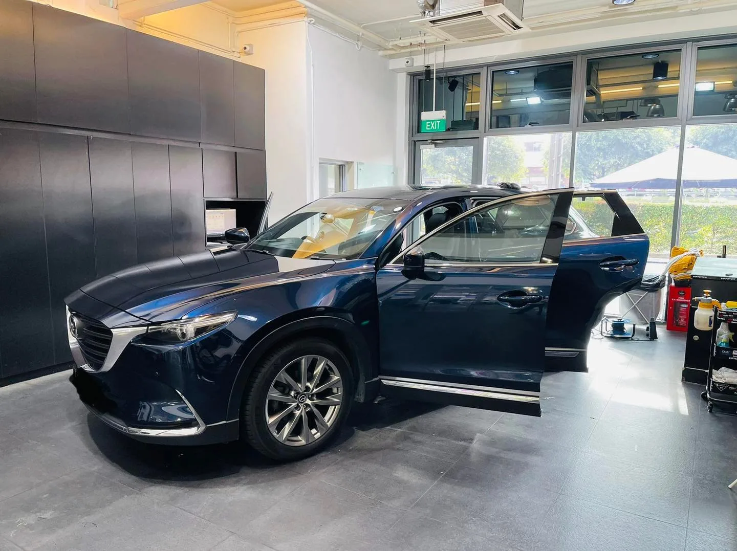 Side profile of a dark blue Mazda CX-9 during window film install at Infratint Singapore