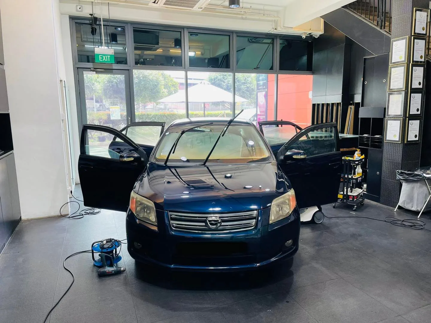 Dark blue Toyota Axio sedan with doors open at Infratint Singapore for window film