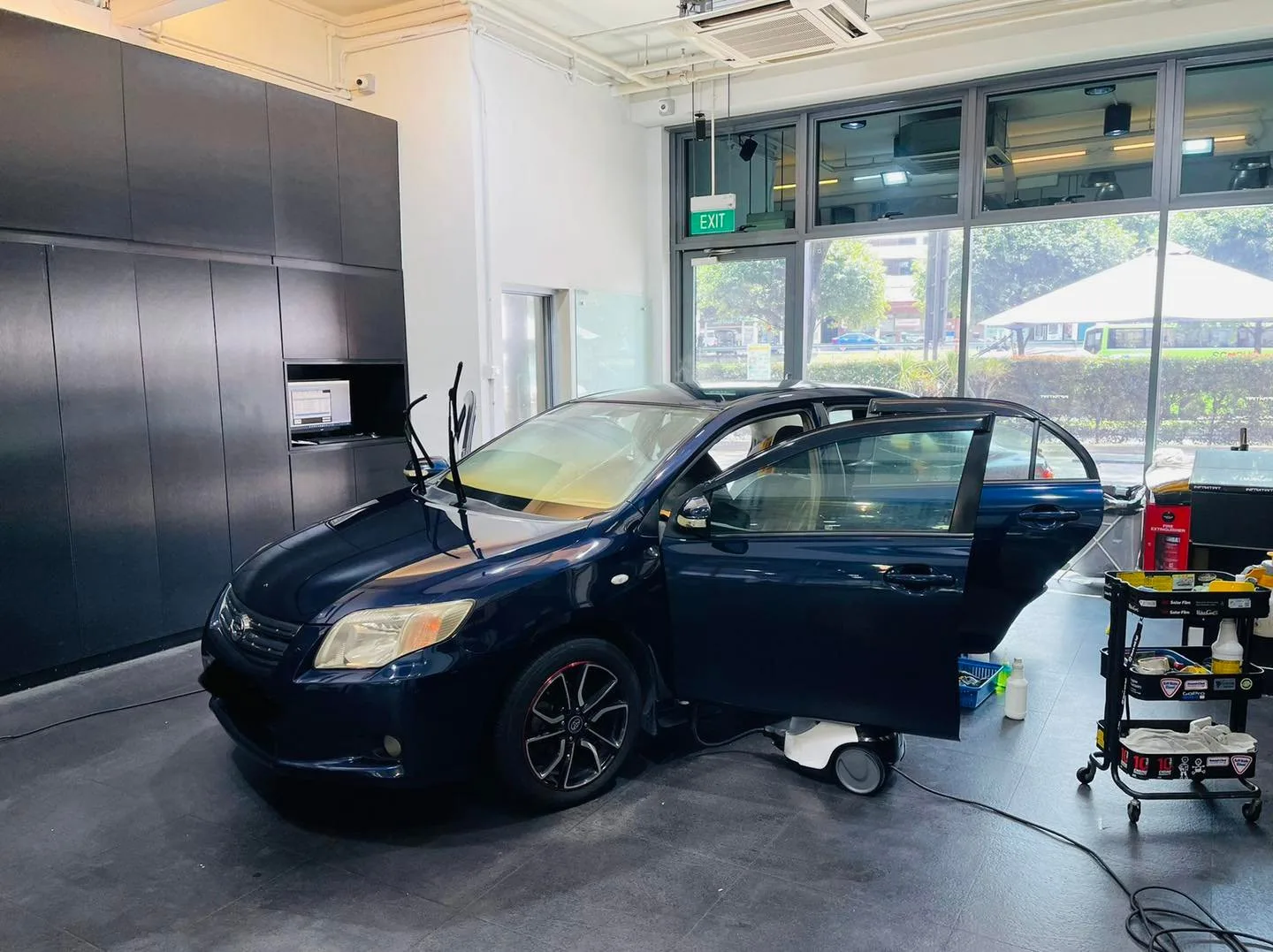 Side view of a dark blue Toyota sedan being tinted at Infratint Singapore