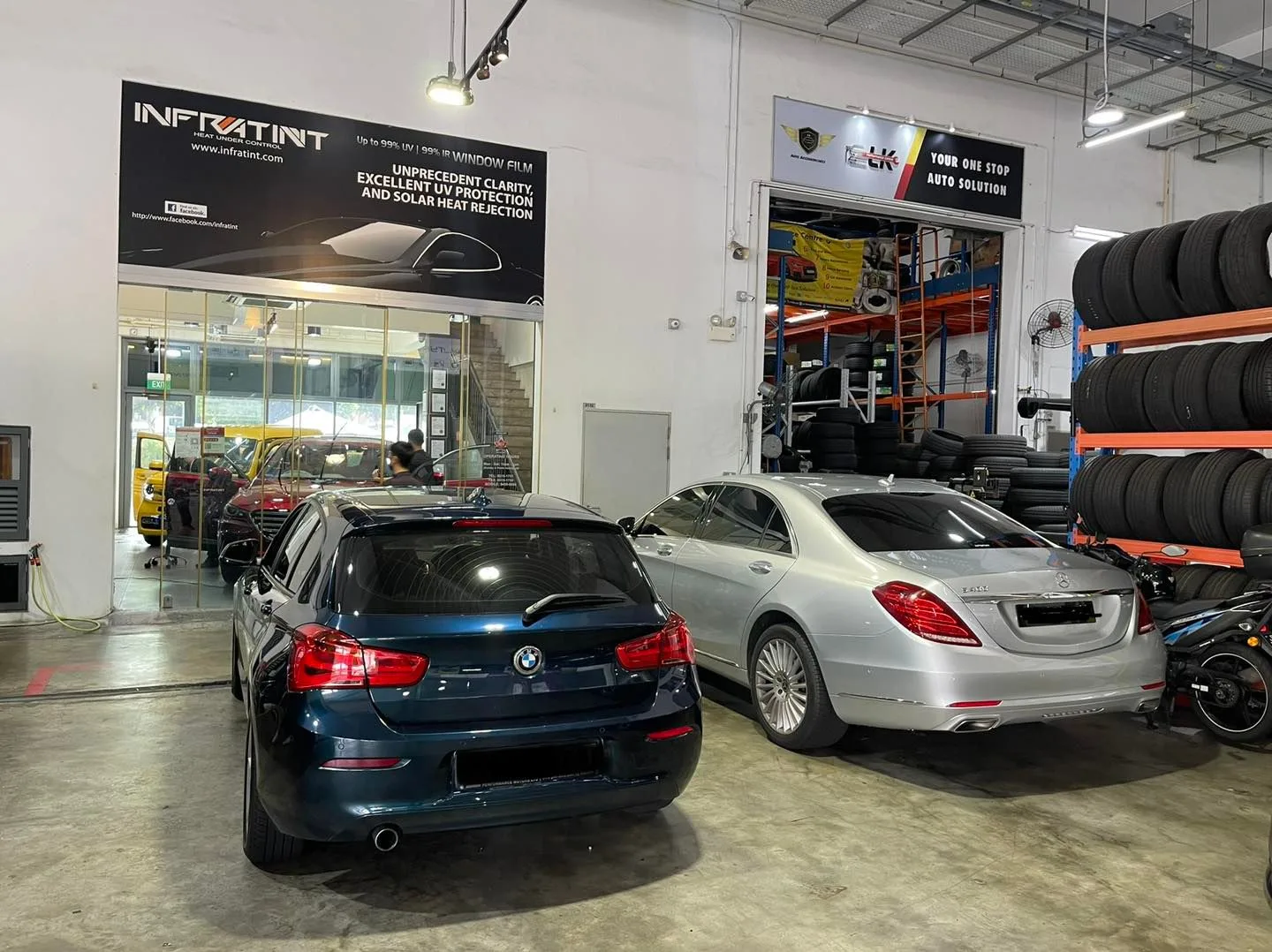 Dark blue BMW 1 Series and silver Mercedes-Benz S-Class from the rear at Infratint Singapore