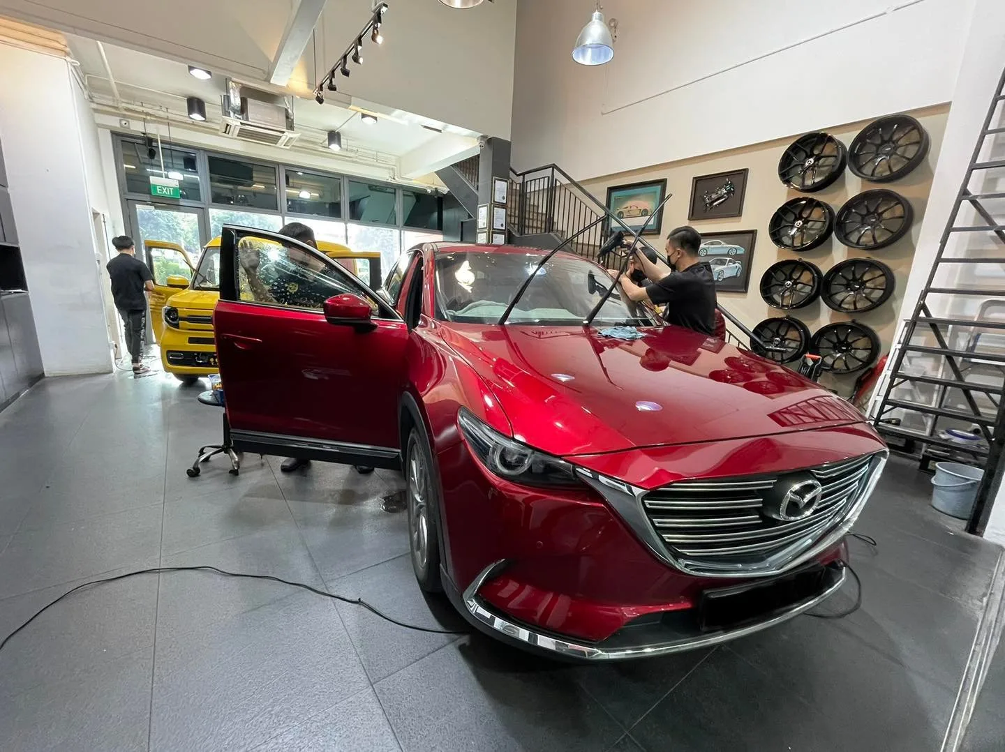 Red Mazda CX-9 in three-quarter view during window tinting at Infratint Singapore