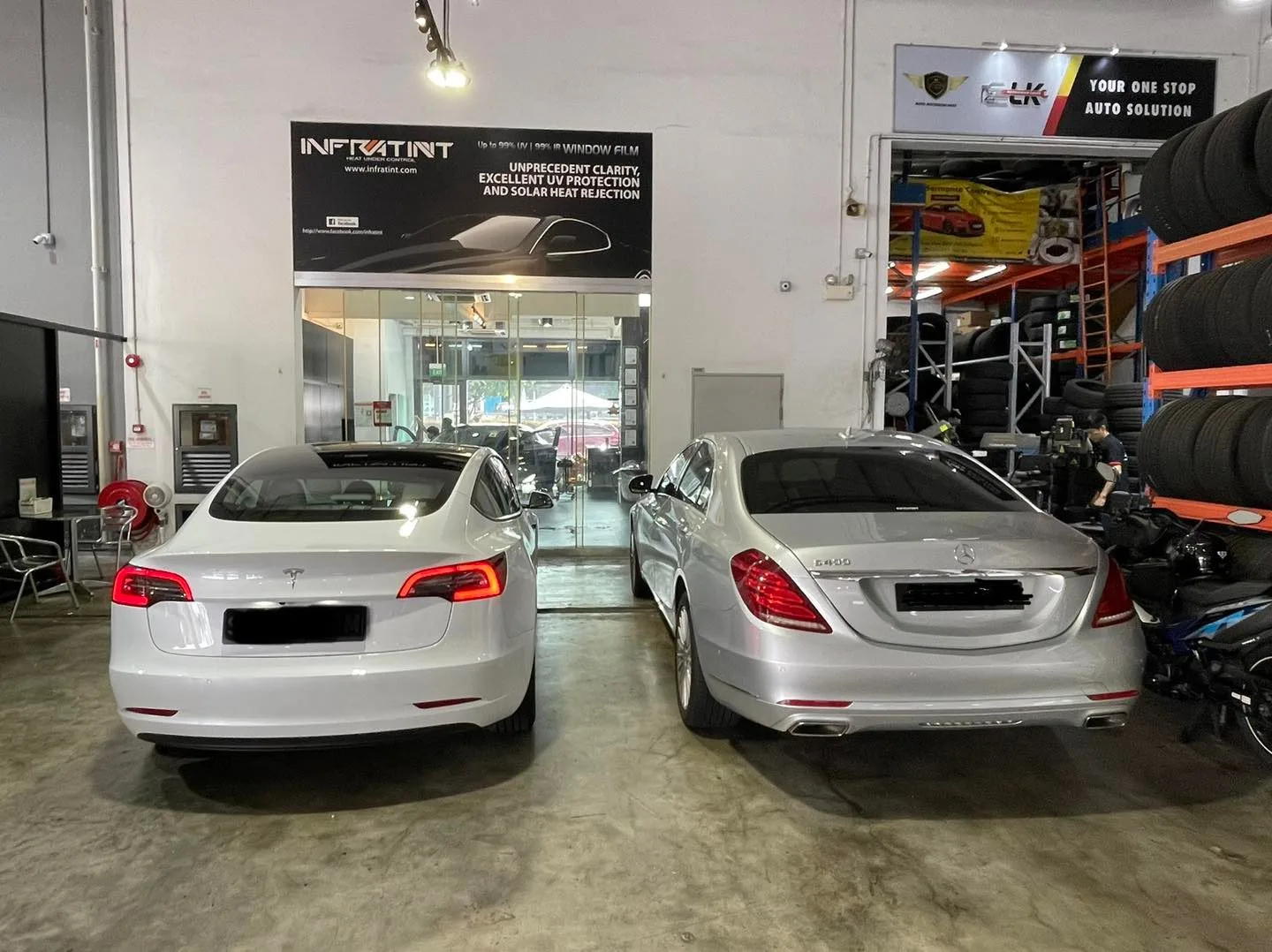 Silver Tesla Model 3 and silver Mercedes-Benz sedan from the rear at Infratint Singapore