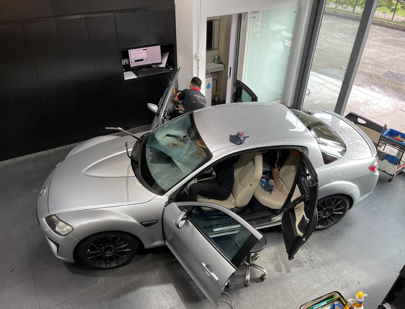 Overhead view of a silver Mazda RX-8 coupe during window tinting at Infratint Singapore