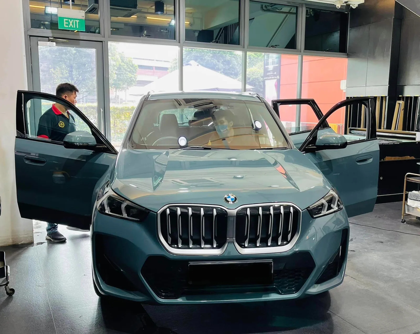 Petrol-blue BMW X1 SUV with doors open at Infratint Singapore for window film