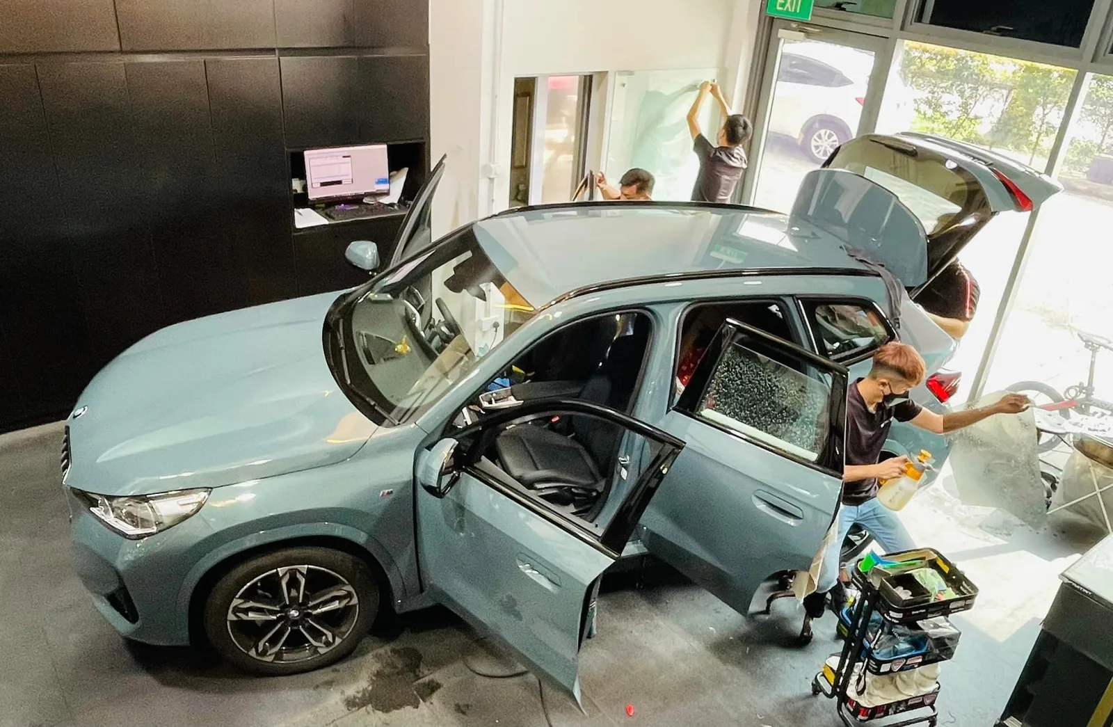 Overhead view of a teal BMW X1 SUV being tinted at Infratint Singapore