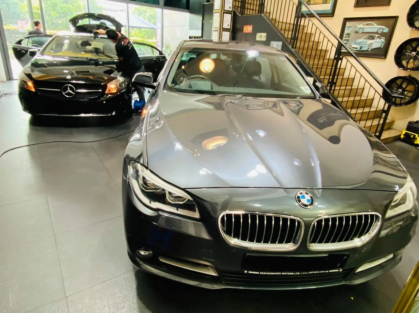 Grey BMW 5 Series and black Mercedes-Benz inside the Infratint Singapore install bay