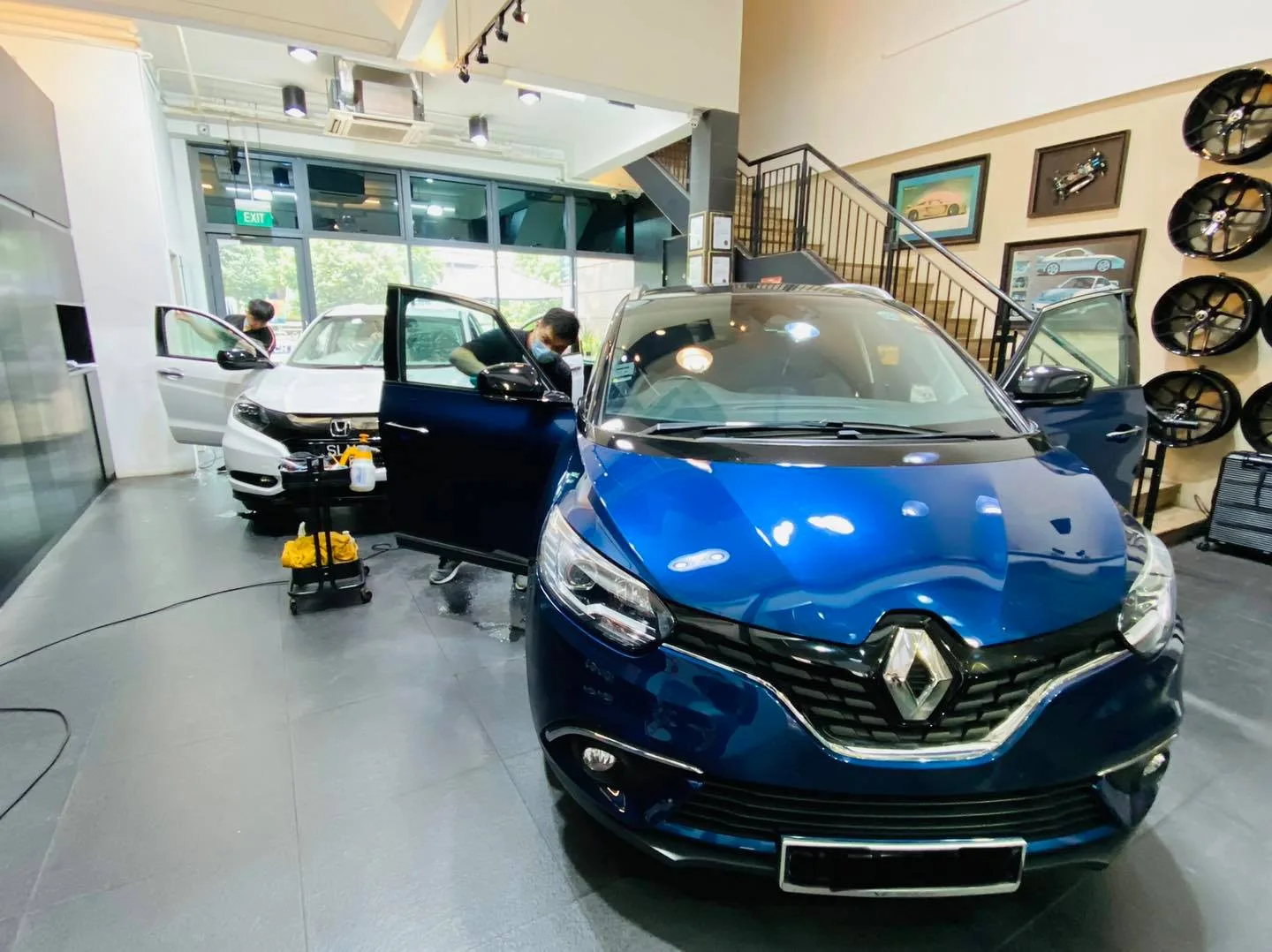 Blue Renault MPV and a white Honda inside the Infratint Singapore showroom