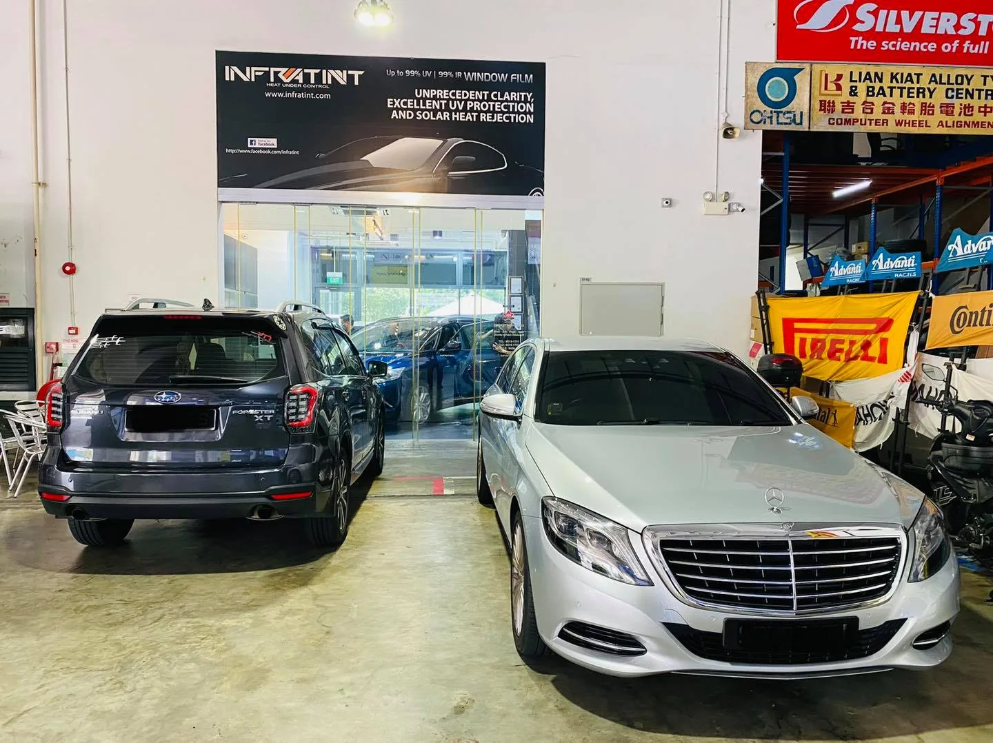 Grey Subaru SUV and silver Mercedes-Benz sedan below the Infratint banner in Singapore