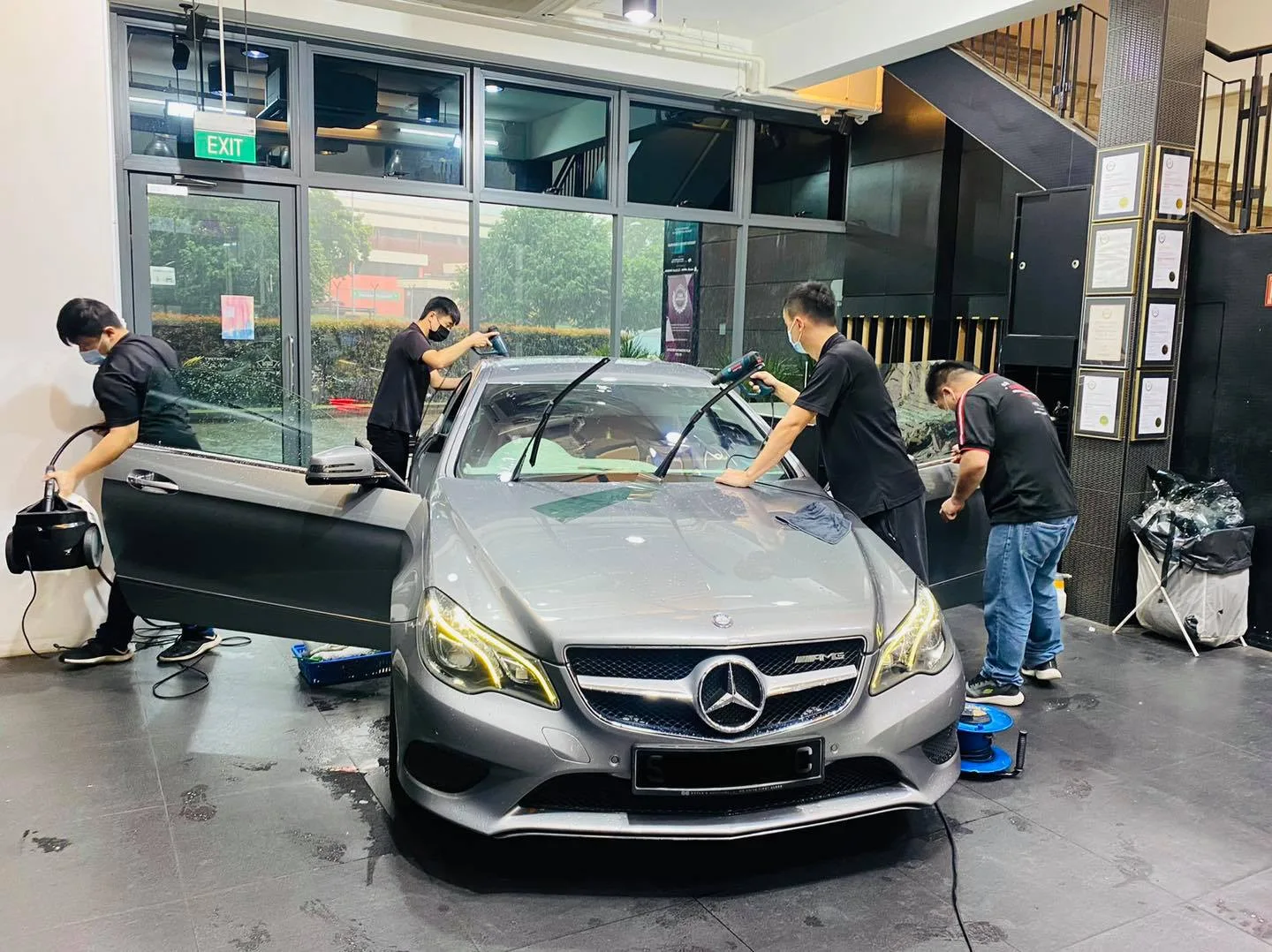 Tinters installing film on a grey Mercedes-Benz E-Class coupe at Infratint Singapore