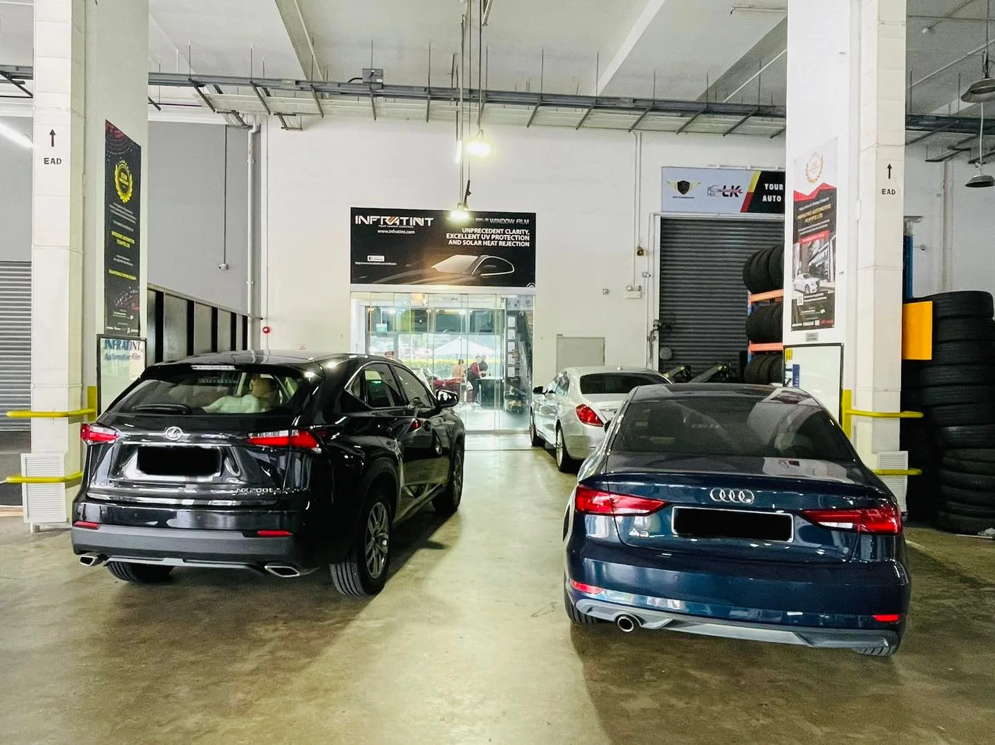 Black Lexus SUV and blue Audi sedan from behind at Infratint Singapore for window tinting