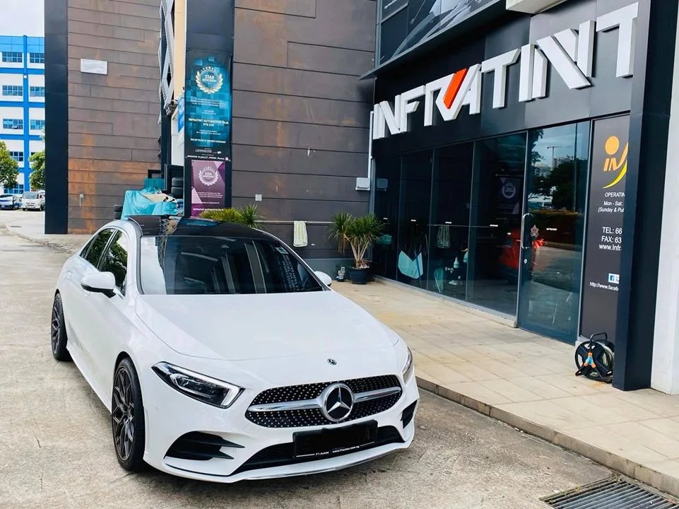 White Mercedes-Benz AMG Line sedan at the Infratint Singapore shopfront after window tinting