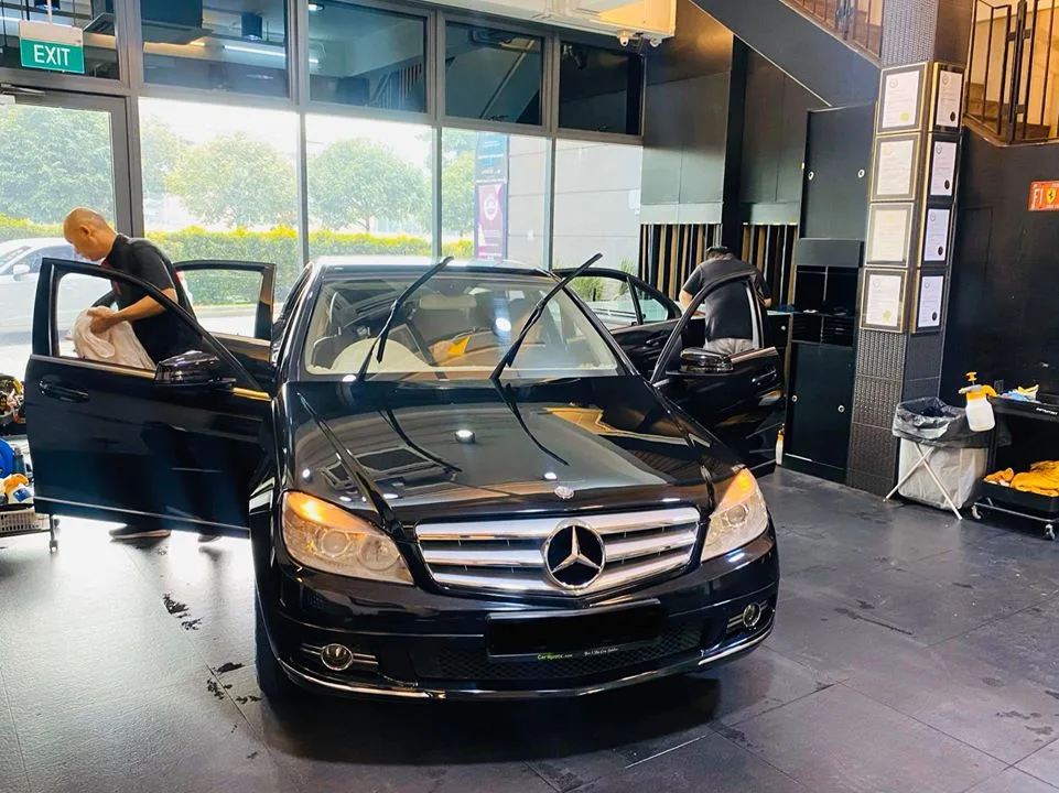 Black Mercedes-Benz C-Class sedan with front doors open during tinting prep at Infratint Singapore