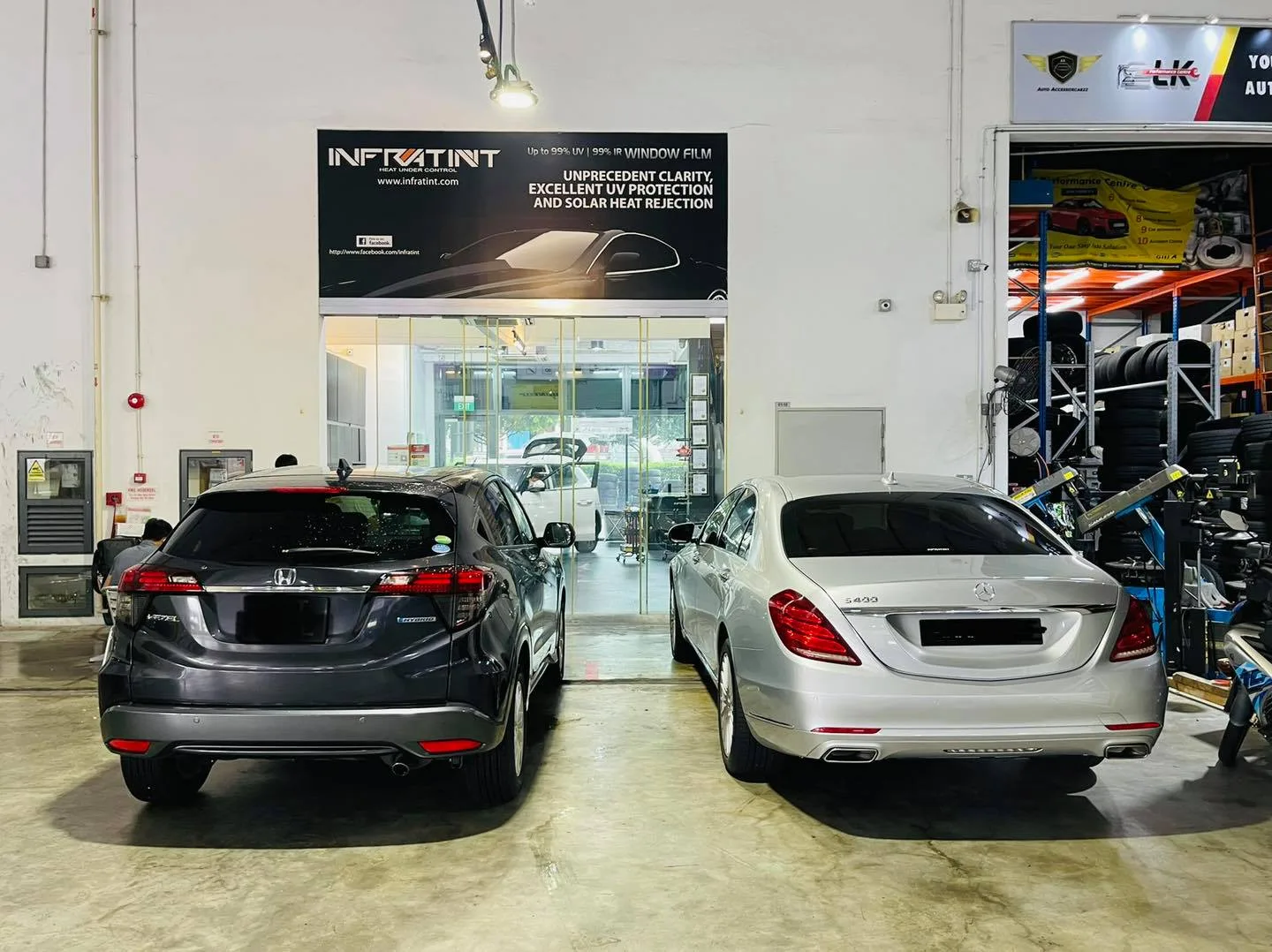 Grey Honda SUV and silver Mercedes-Benz S-Class under the Infratint banner in Singapore