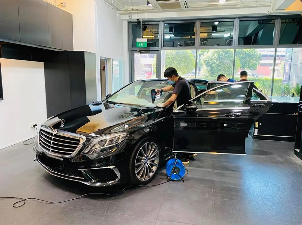 Technician using a heat gun on a black Mercedes-Benz S-Class at Infratint Singapore