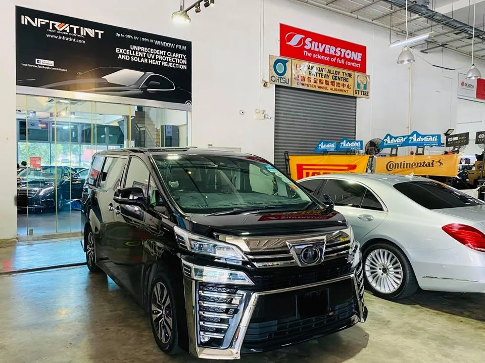 Black Toyota Vellfire and silver Mercedes-Benz sedan beneath the Infratint Singapore banner