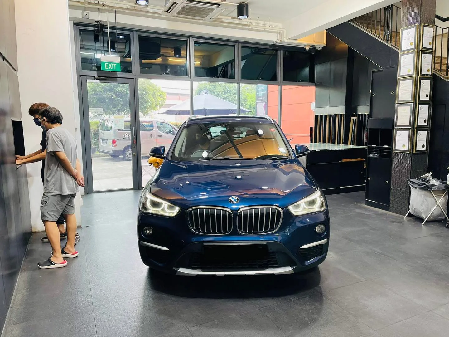 Blue BMW X1 SUV inside the Infratint Singapore showroom for window film