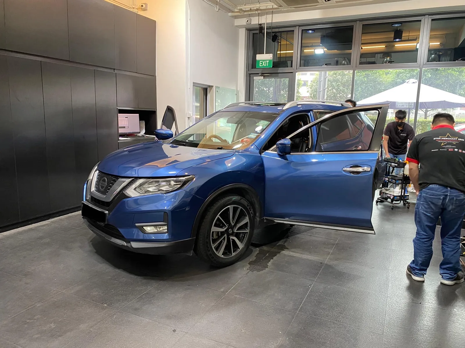Side view of a blue Nissan X-Trail being tinted at Infratint Singapore