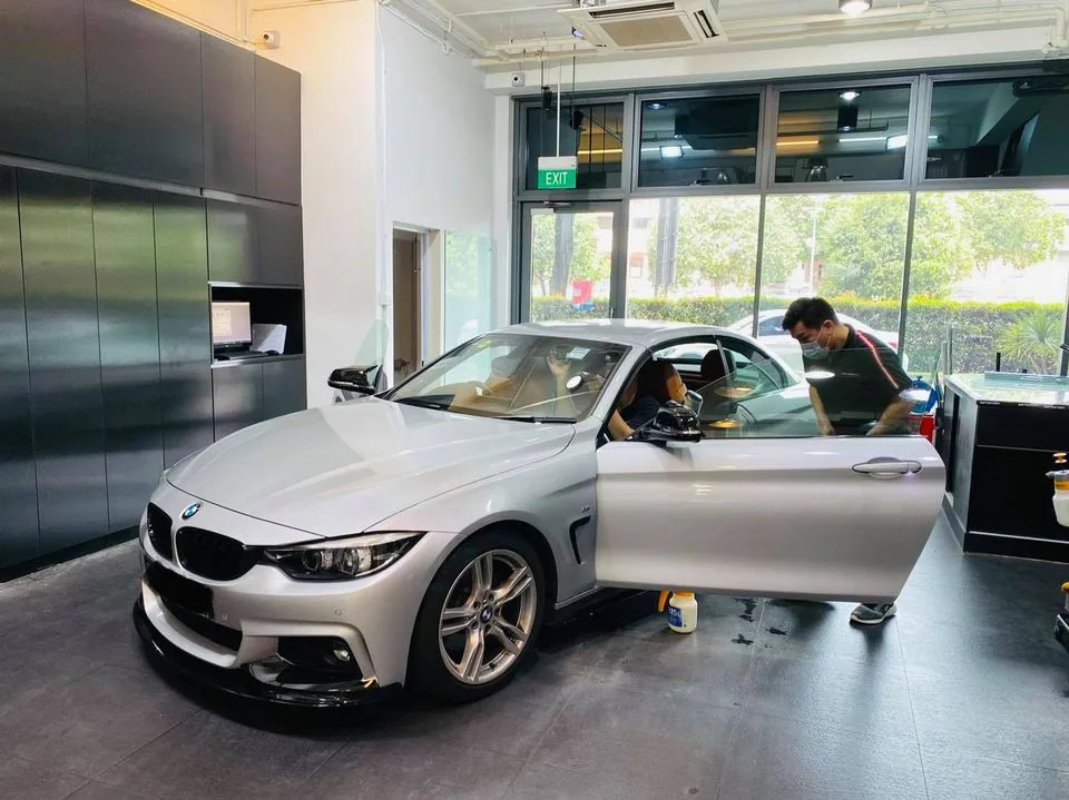 Installer tinting the rear window of a silver BMW 4-Series at Infratint Singapore