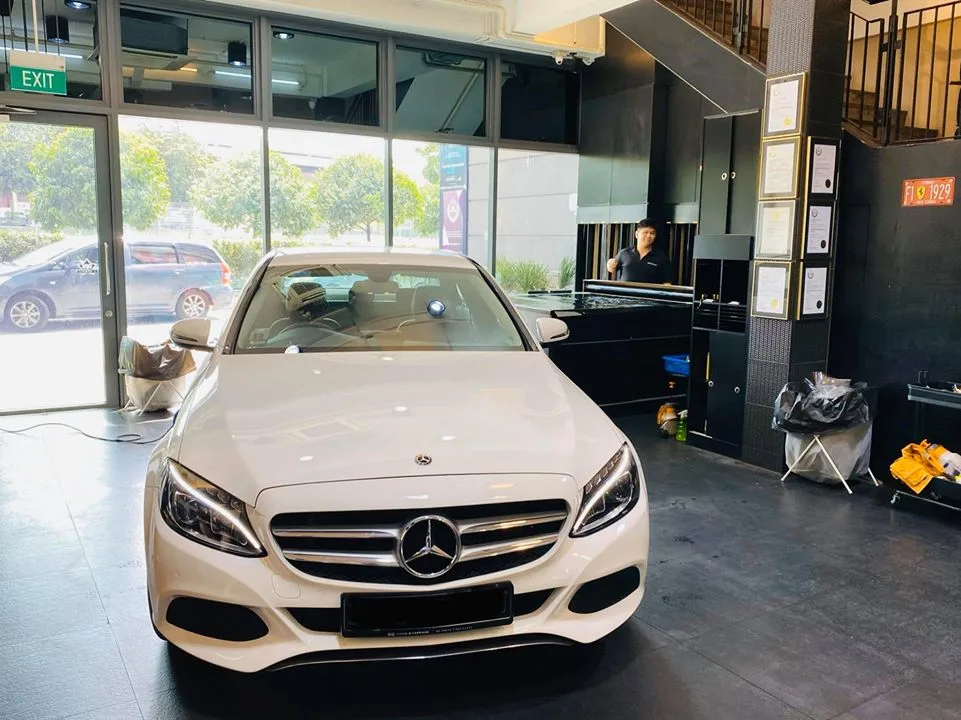 White Mercedes-Benz C-Class sedan facing forward in the Infratint Singapore showroom