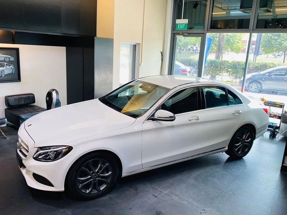 Front three-quarter view of a white Mercedes-Benz C-Class after tinting at Infratint Singapore