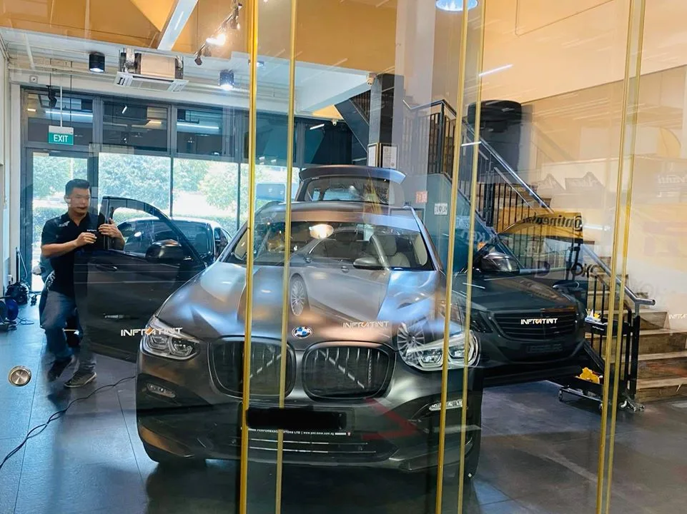 Grey BMW SUV with door open being prepared for window tinting at Infratint Singapore