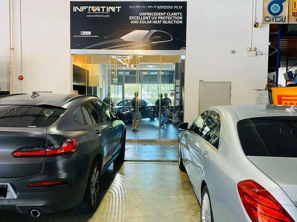 Grey BMW coupe-SUV and silver Mercedes-Benz sedan waiting for window tinting at Infratint Singapore
