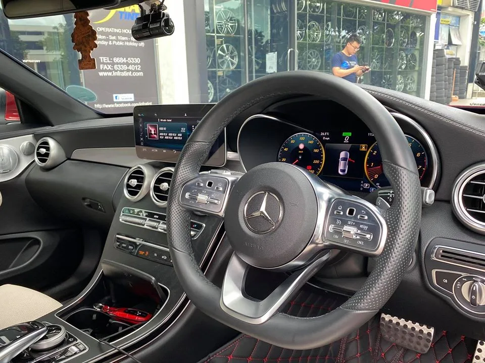 Mercedes-Benz C-Class interior with steering wheel and dashboard viewed through tinted windows at Infratint Singapore