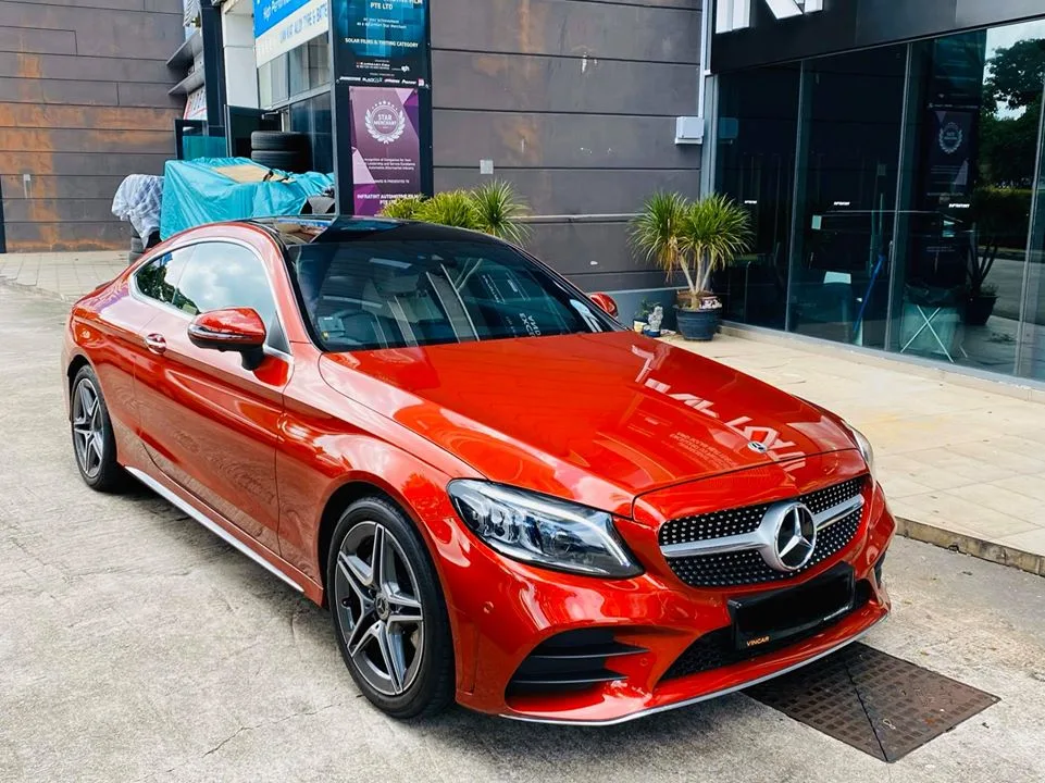 Orange Mercedes-Benz C-Class coupe parked outside Infratint Singapore after window tinting