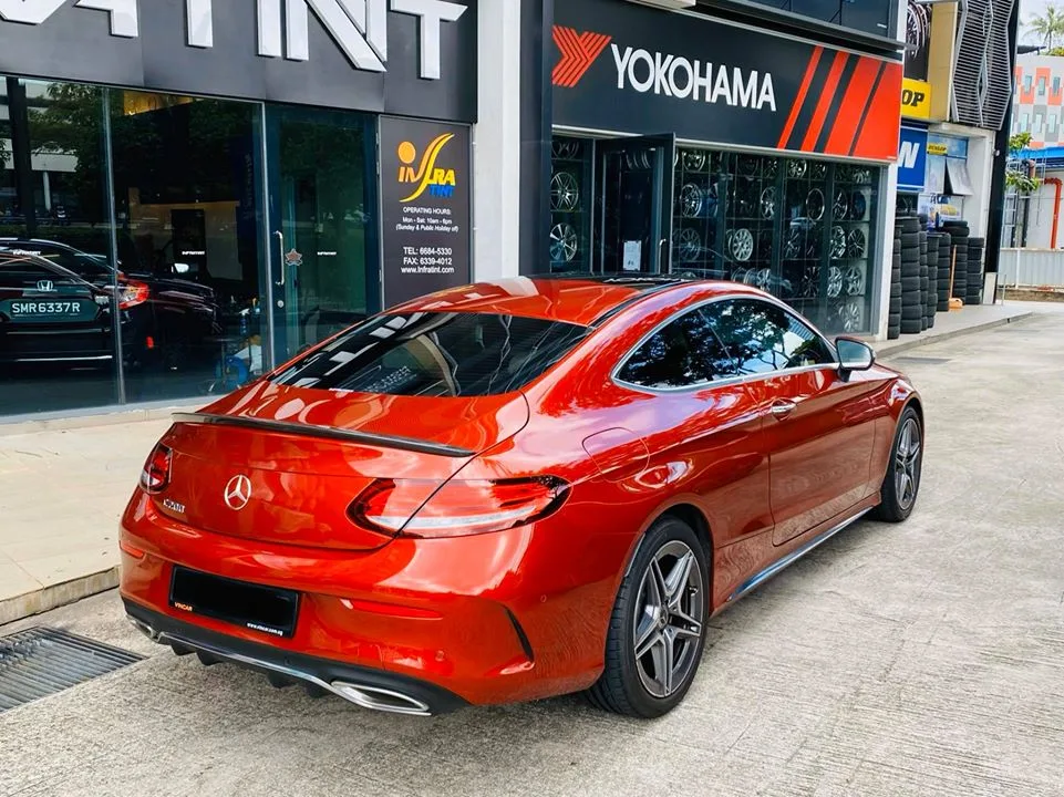 Rear three-quarter of an orange Mercedes-Benz coupe with tinted windows at Infratint Singapore
