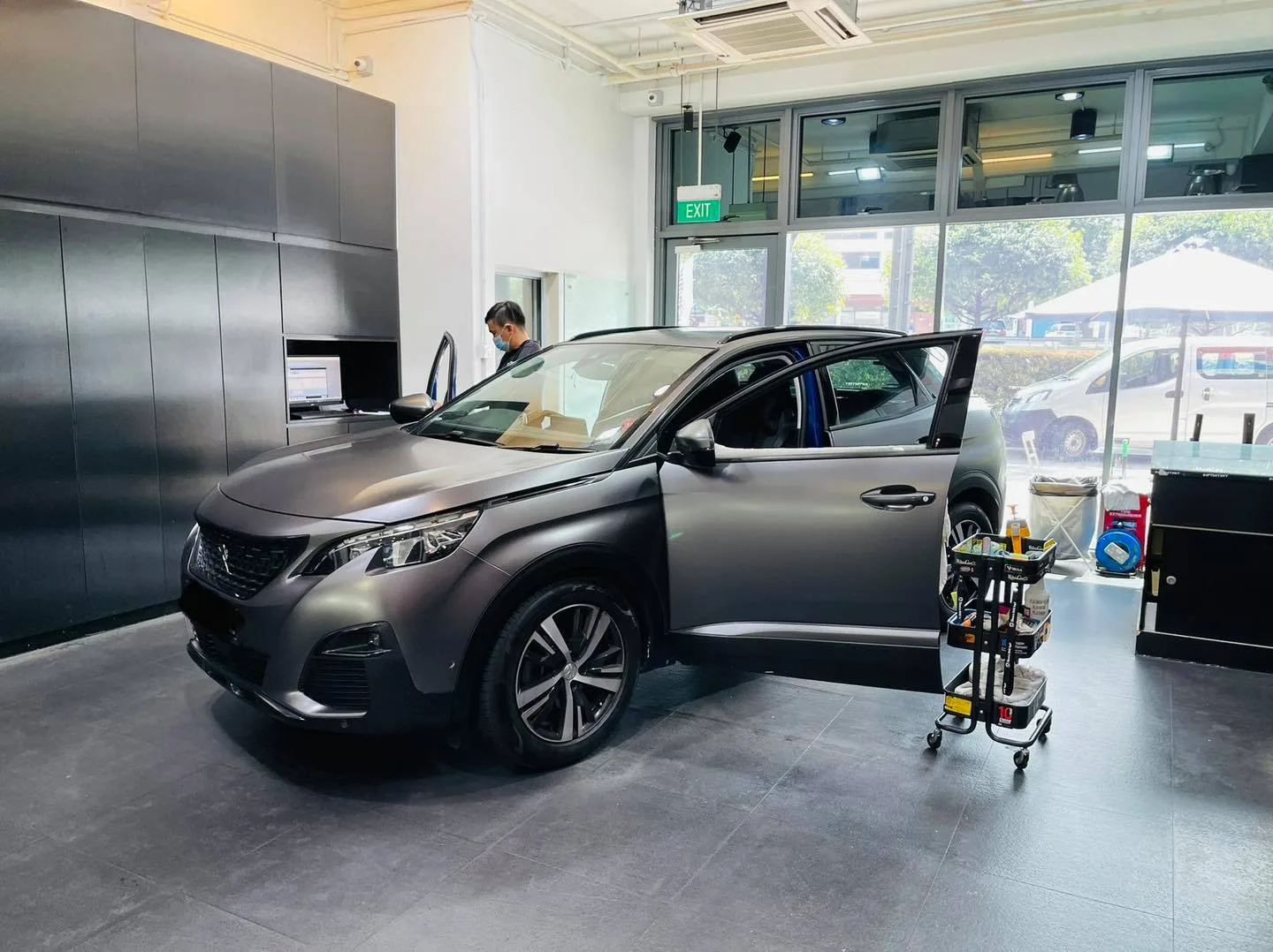 Installer tinting a matte grey Peugeot SUV at Infratint Singapore