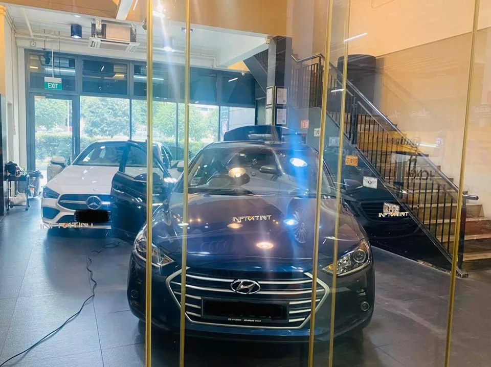 Dark blue Hyundai sedan and white Mercedes-Benz CLA in the Infratint Singapore showroom