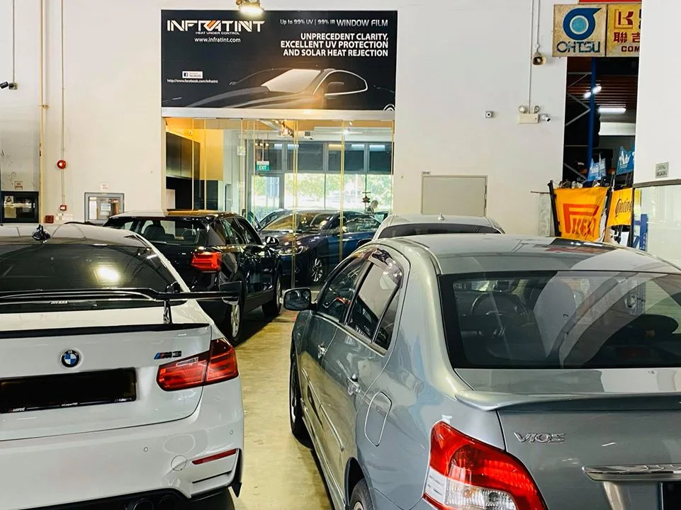 White BMW M3 sedan and grey Toyota Vios in the Infratint Singapore bay