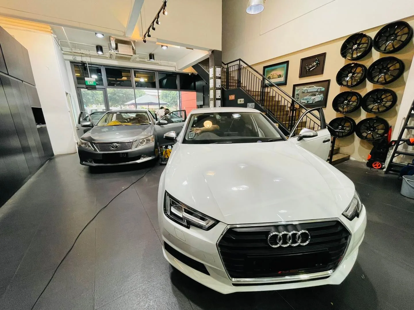 White Audi sedan and grey Toyota Camry inside the Infratint Singapore showroom
