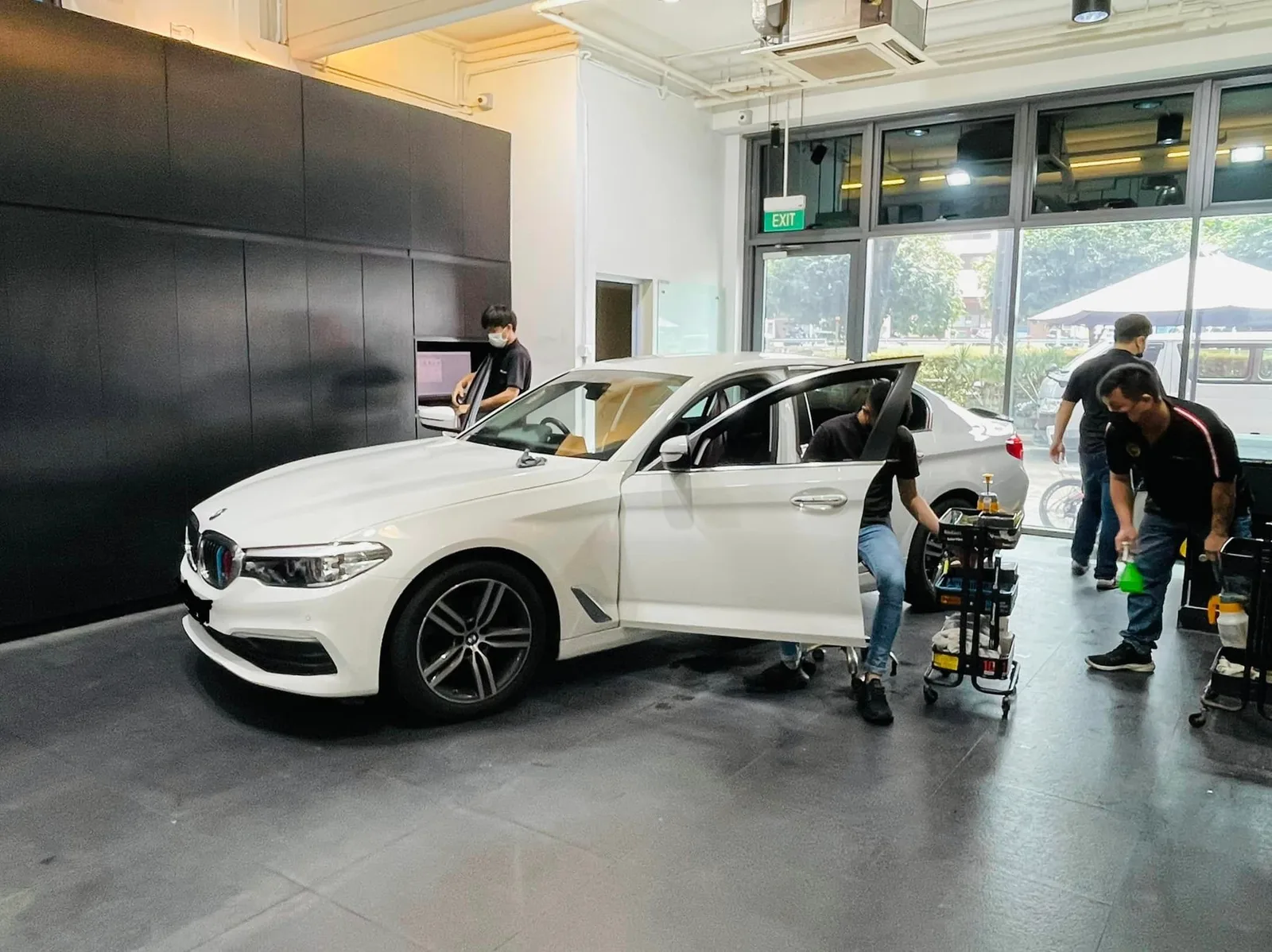 White BMW 5 Series with door open during window tinting at Infratint Singapore