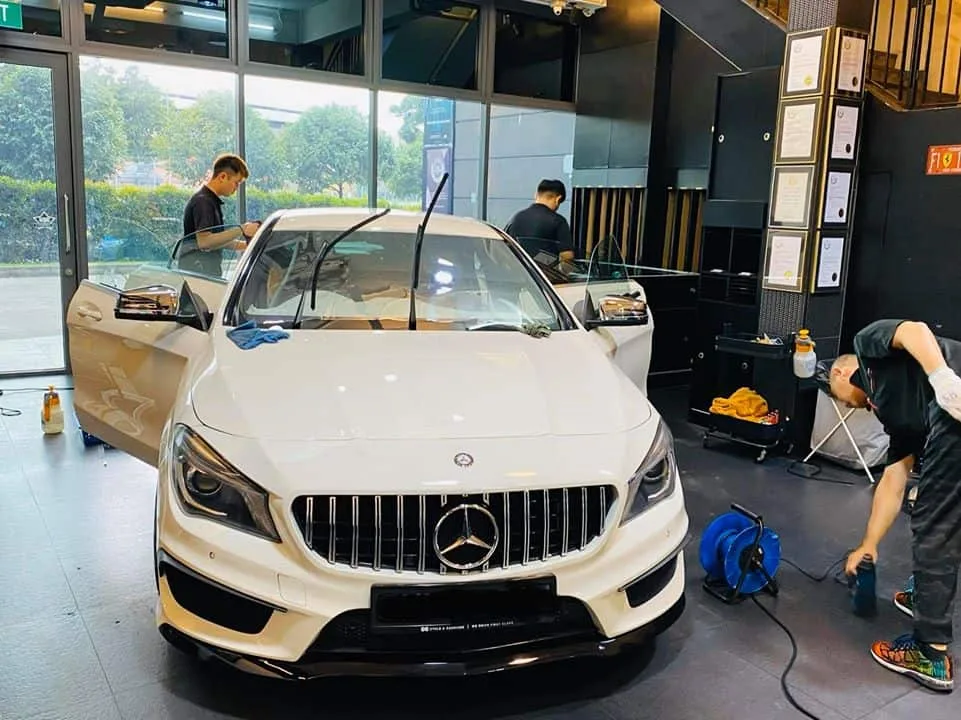 White Mercedes-Benz CLA with wipers up during window tinting prep at Infratint Singapore