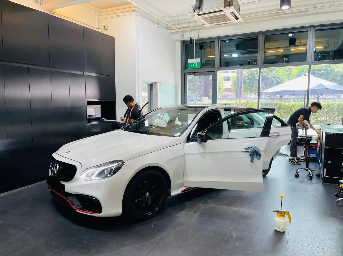 Side view of a white Mercedes-Benz E-Class being prepared for window film at Infratint Singapore