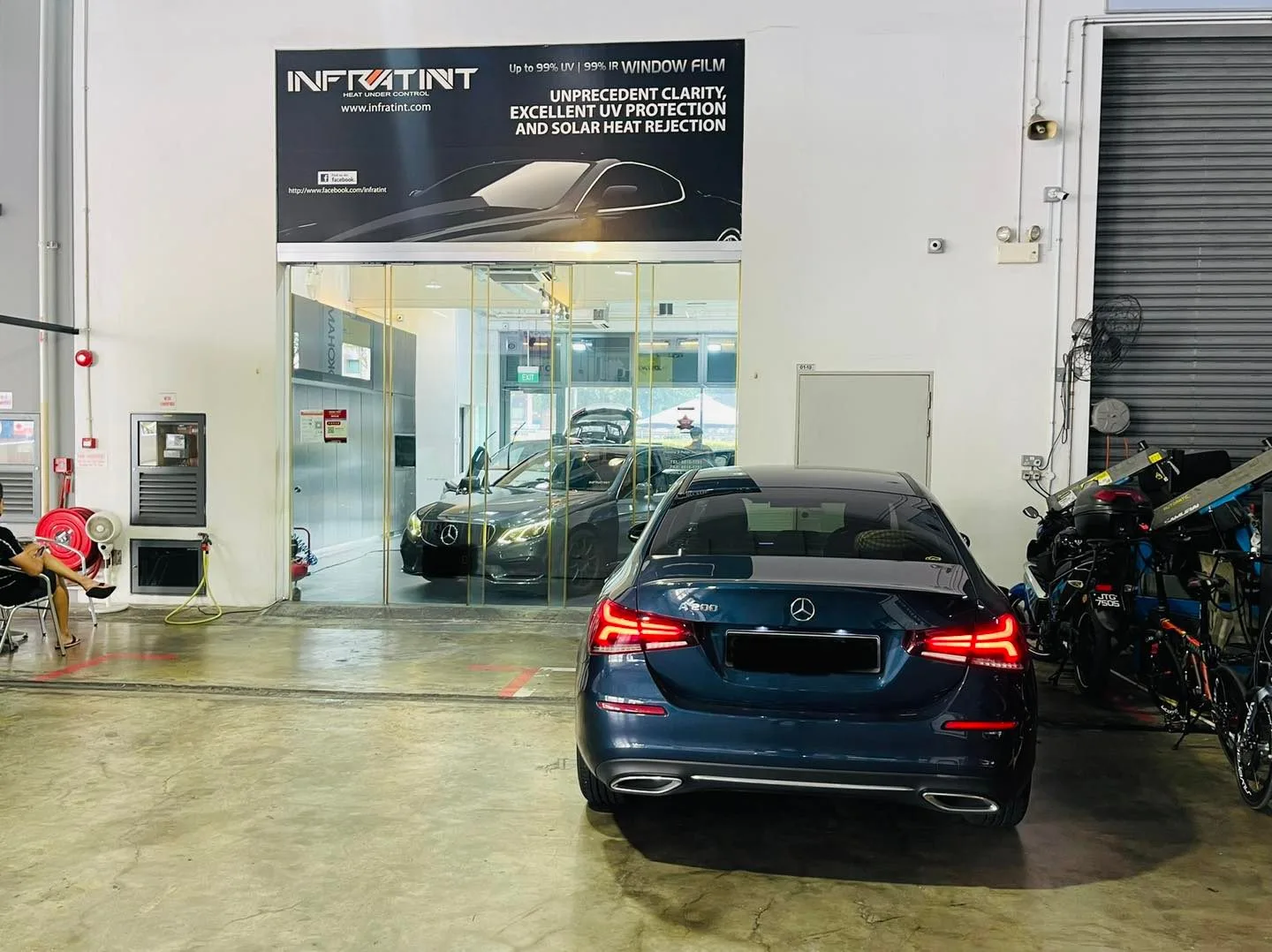 Dark blue Mercedes-Benz sedan parked under the Infratint Singapore banner