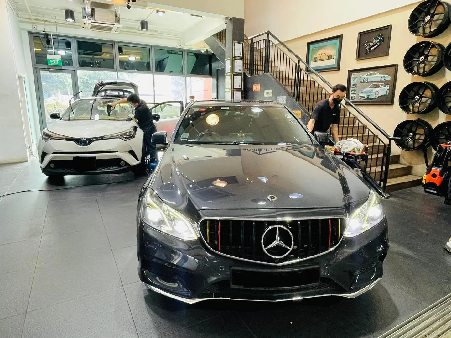 Dark Mercedes-Benz sedan and white Toyota C-HR inside the Infratint Singapore showroom