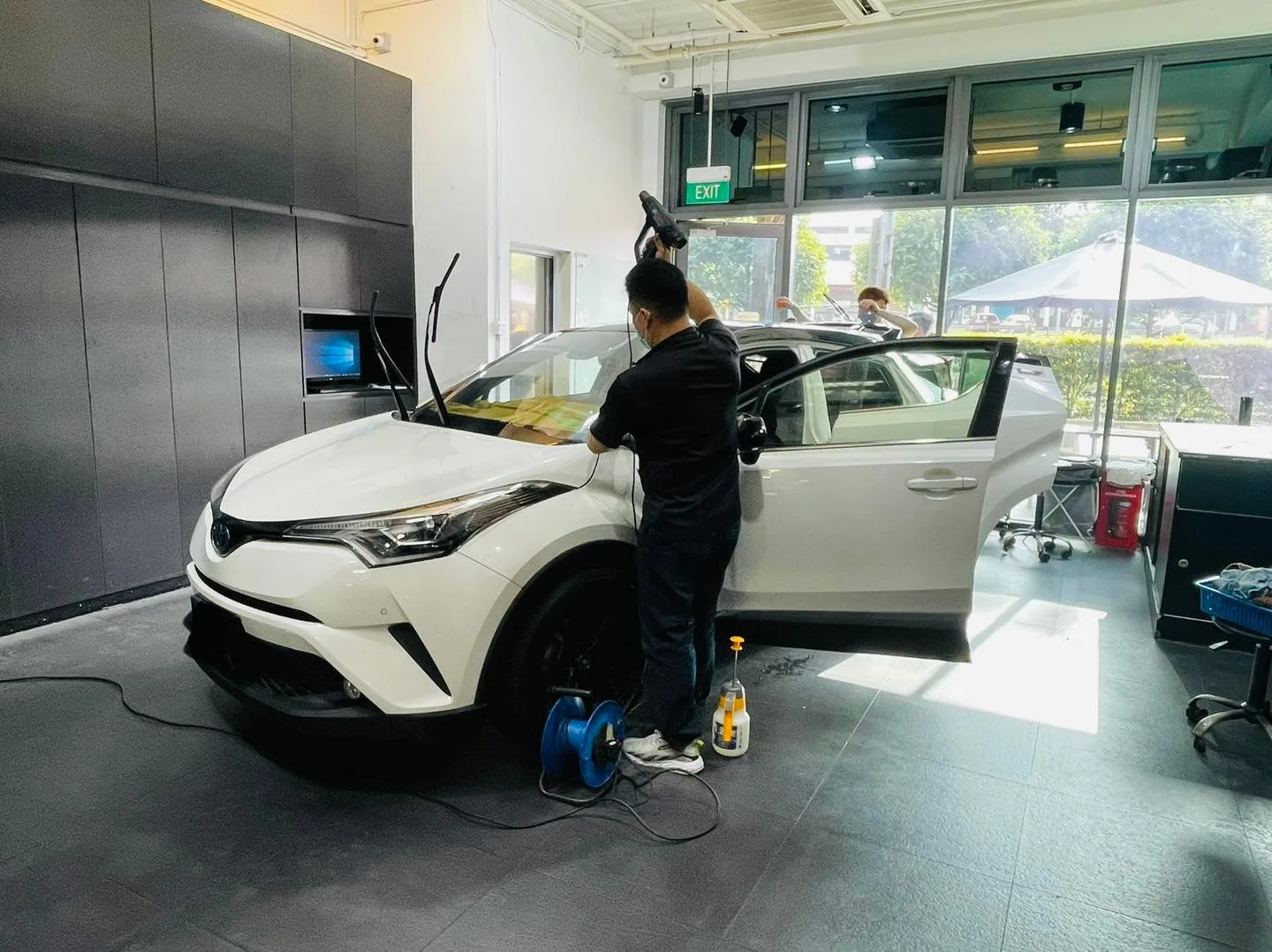 Installer tinting a white Toyota C-HR at Infratint Singapore